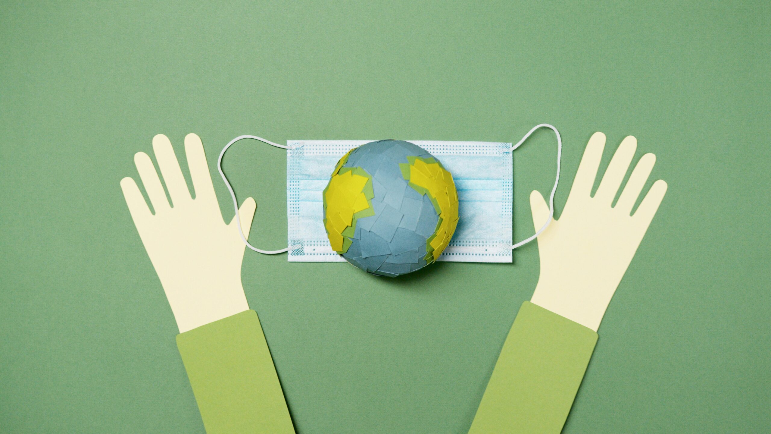 Home Creative image showing a paper-cut Earth on a mask with hands, symbolizing global protection.